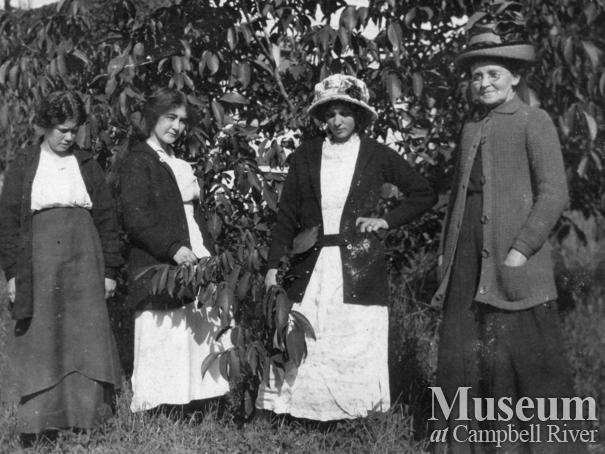 Group of ladies beside the walunt tree at Sunny Side Farm, Quadra Island