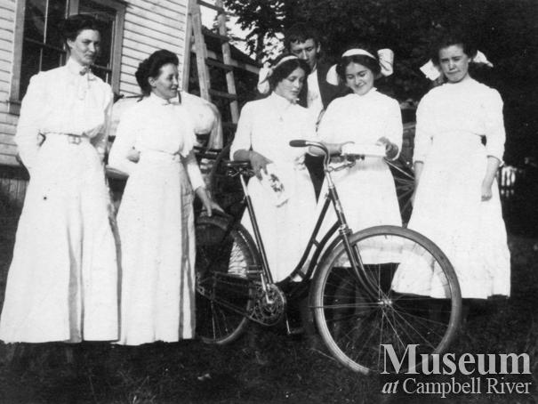 Group of women with bicyle in the Yeatman's back yard, Quadra Island