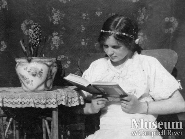 Dot Yeatman reading a book in her home, Quadra Island