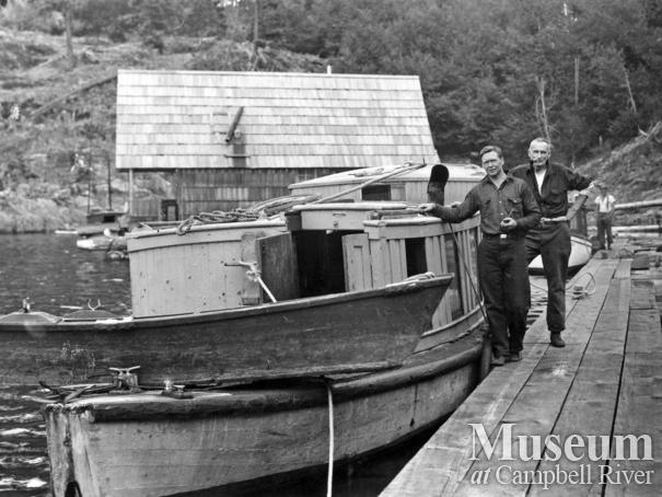 Wood and Armitage beside their boat at Refuge Cove