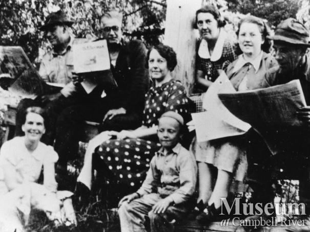 Group Reading the Newspaper at Mansons Landing