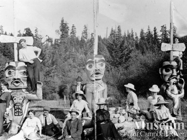 Group posing with carved welcome figures at Cape Mudge Village, Quadra Island