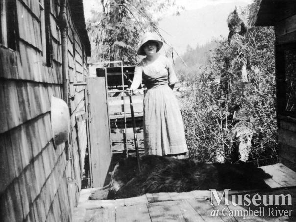 Woman with dead bear at Shoal Bay, Thurlow Island
