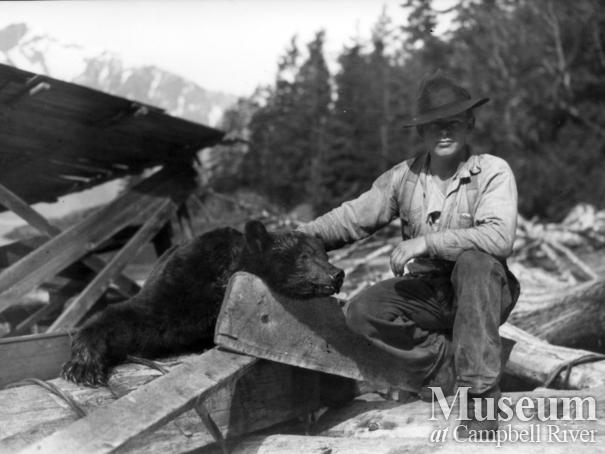 Unidentified man with dead bear