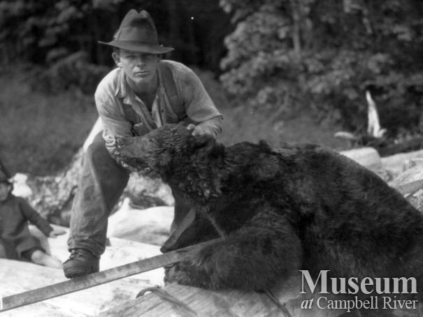 Unidentified man with dead bear